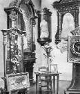 St. Therese: Her veil and Carmelite robe with crown, one of her childhood dresses, her communion dress, small chair and table by which she painted, paint pallet, the lilies from the first coffin she was in, a cross made from 2 boards of the first coffin along with the palm leaf that was placed in the first coffin.